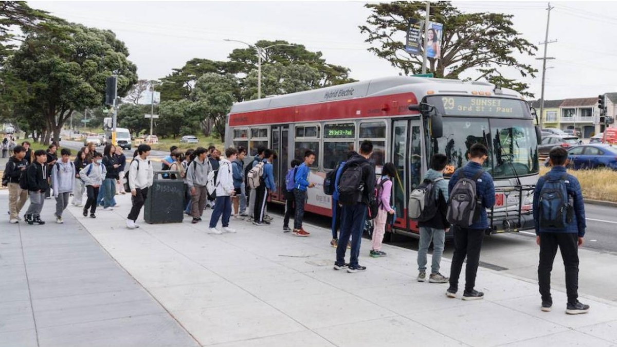Muni riders boarding a hybrid-electric bus in San Francisco, representing the fleet choices at issue in SFMTA’s zero-emission exemption request.